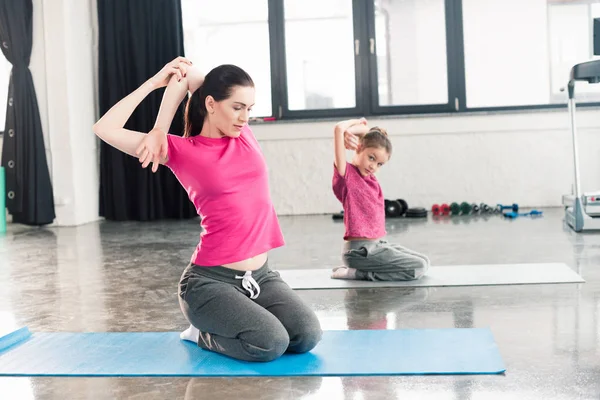 Mother and daughter sitting on yoga mats — Stock Photo, Image