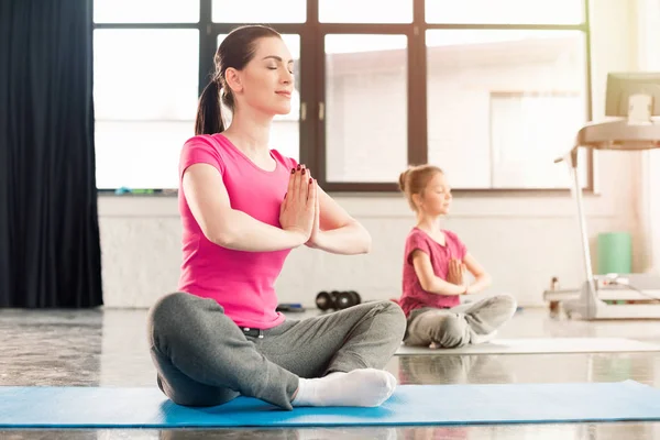 Mother and daughter in lotus pose — Stock Photo, Image
