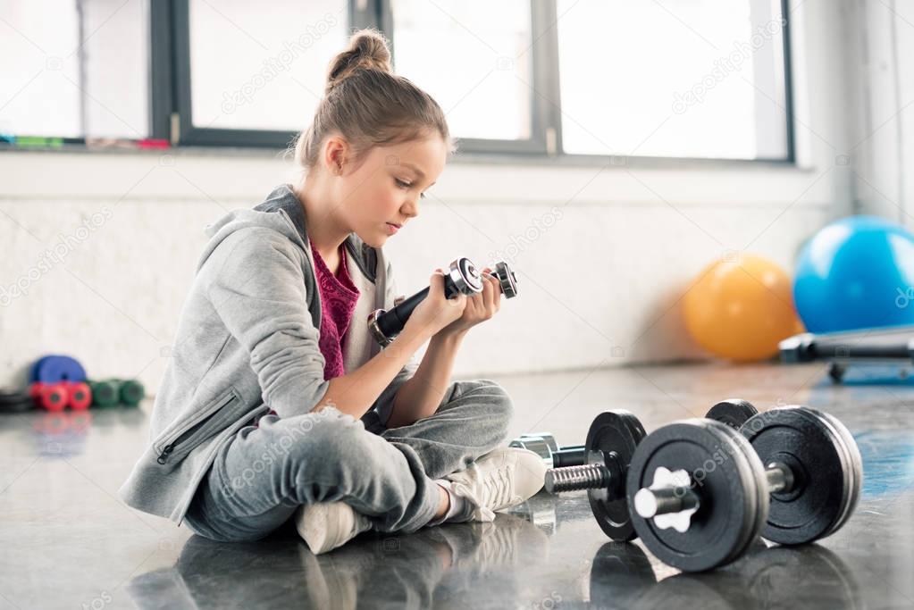 Girl exercising with dumbbells 