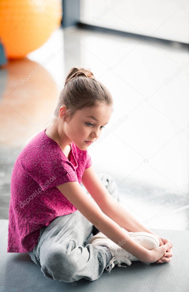 girl sitting on yoga mat