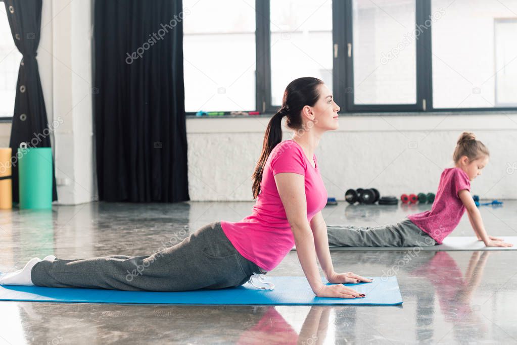 mother and daughter practicing yoga