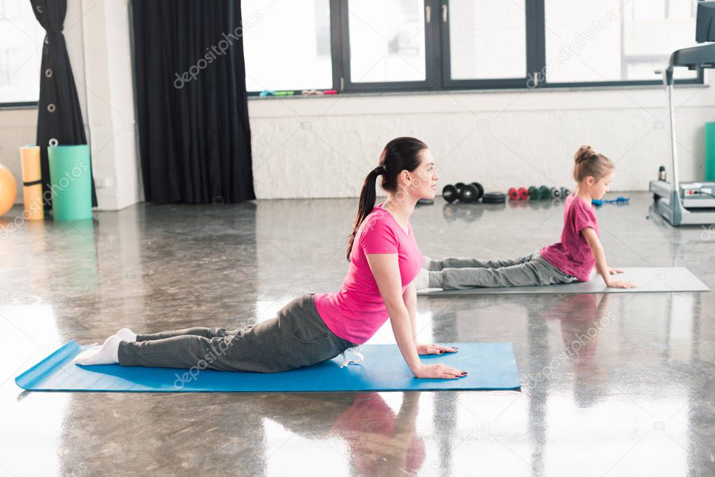 mother and daughter practicing yoga