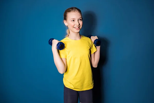 Preteen girl training with dumbbells — Stock Photo, Image