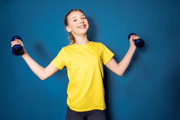 Preteen girl training with dumbbells — Stock Photo, Image