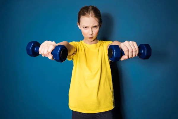 Preteen girl training with dumbbells — Stock Photo, Image