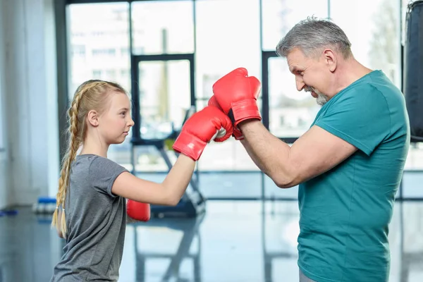 preteen girl boxing with trainer.