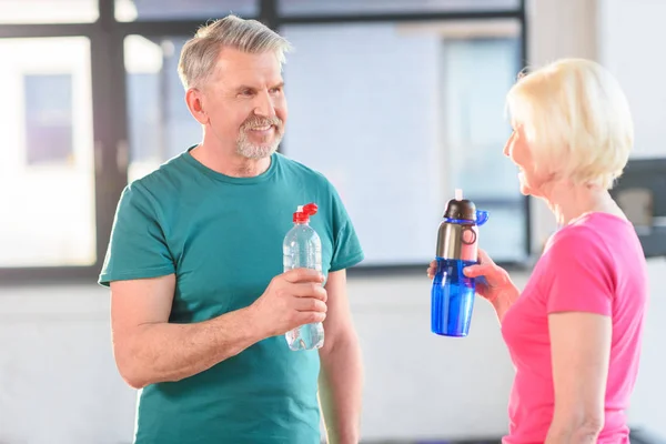 Pareja beber agua en el gimnasio — Foto de Stock