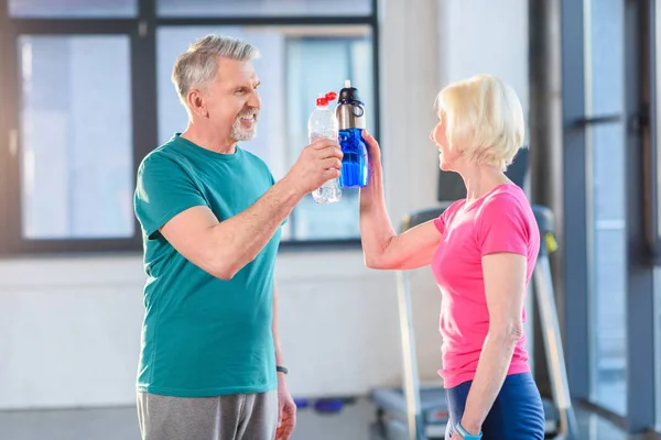 Paar trinkt Wasser in Turnhalle — Stockfoto