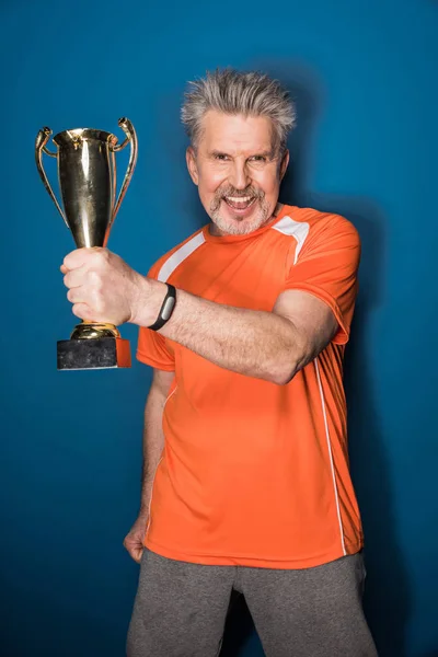 Старший спортсмен с трофеем — Бесплатное стоковое фото