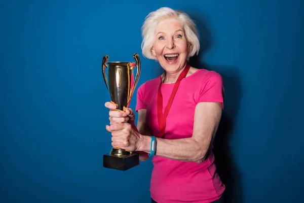 Senior sportswoman holding trophy — Stock Photo, Image