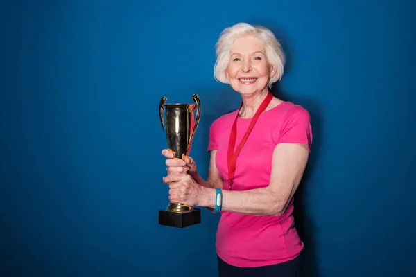 Senior sportswoman holding trophy — Stock Photo, Image