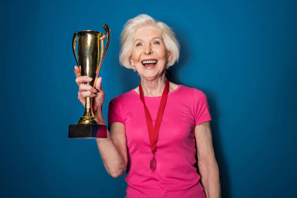 Senior sportswoman holding trophy  