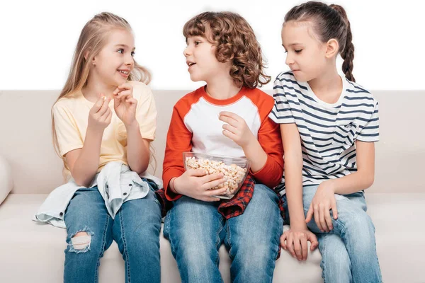 Cute children on couch with popcorn — Stock Photo, Image