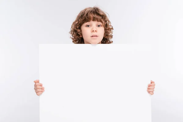 Niño sosteniendo blanco tablero en blanco — Foto de Stock