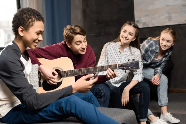 Tonåringar som spelar akustisk gitarr — Stockfoto