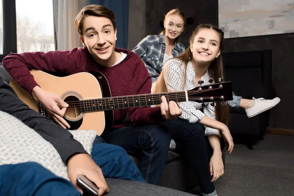 Adolescentes tocando guitarra acústica — Fotografia de Stock