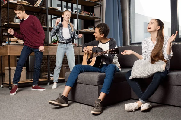 Adolescentes tocando guitarra acústica — Fotografia de Stock