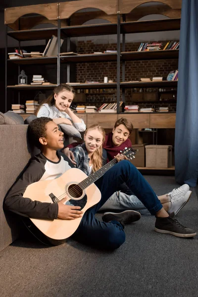 Adolescentes tocando guitarra acústica — Fotografia de Stock