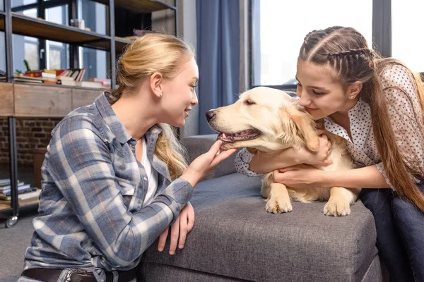 Meninas abraçando cão — Fotografia de Stock