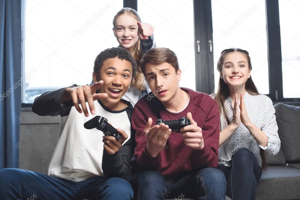 multicultural teenagers with joysticks