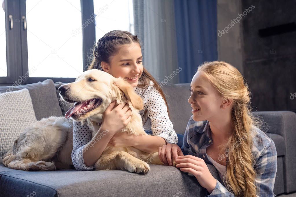 girls hugging dog