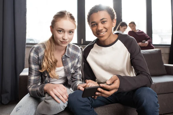 Teenage couple using smartphone — Stock Photo, Image