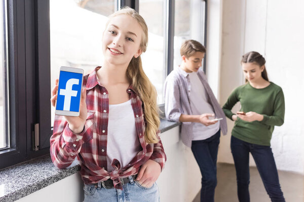 девочка-подросток показывает смартфон
