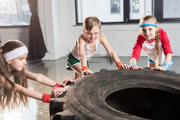 Crianças treinando com pneu no estúdio de fitness — Fotografia de Stock