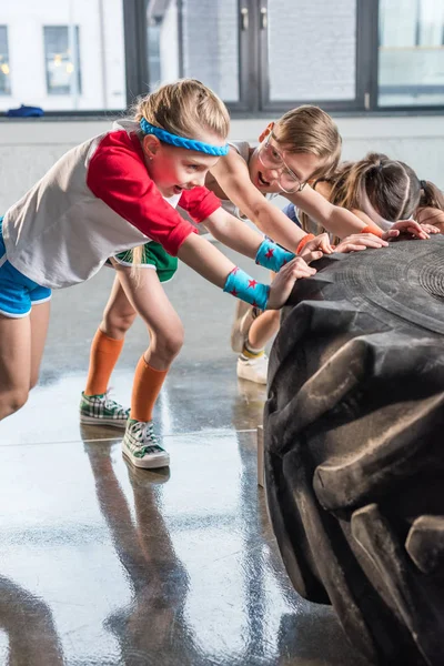 Barn utbildning med däck på fitnesstudio — Stockfoto