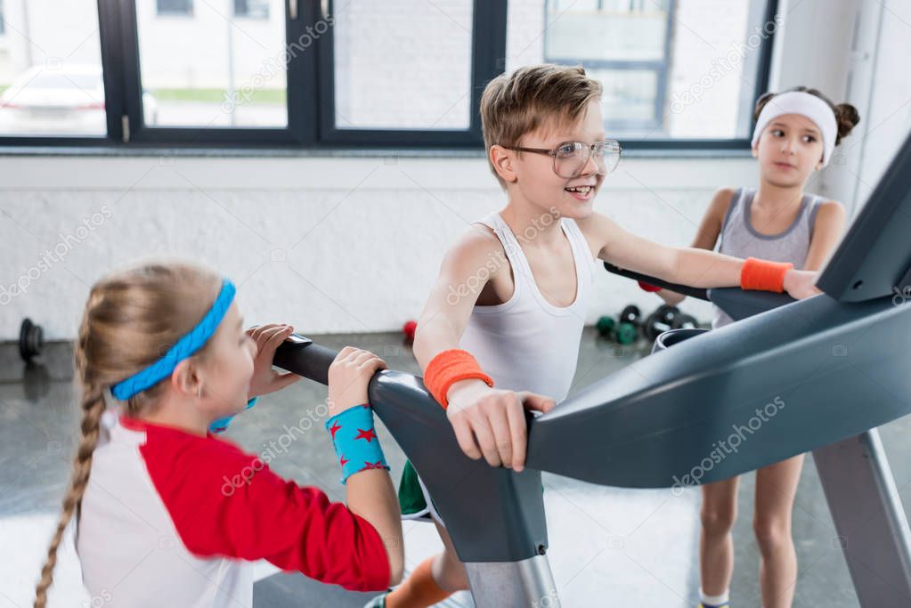 kids in sportswear training on treadmill