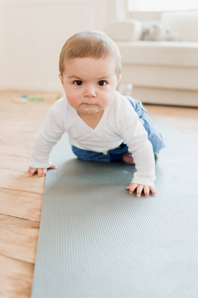 baby boy crawling on yoga mat