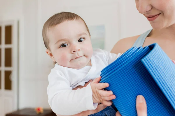 Kvinna som bär baby barn på armar — Stockfoto