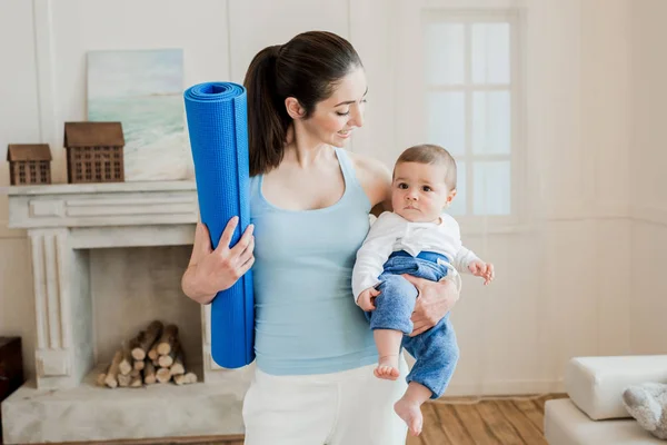 Žena, která nosí baby dítě na zbraně — Stock fotografie