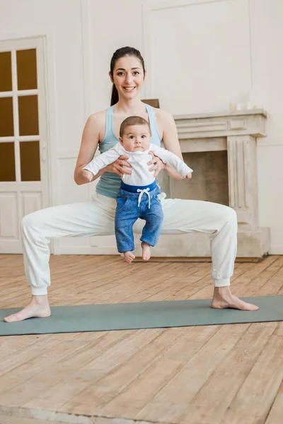 Мати з маленьким хлопчиком практикує йогу — стокове фото