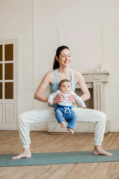 Мама с маленьким мальчиком практикует йогу — стоковое фото