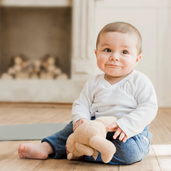 Oyuncak ayı ile oturan bebek boy gülümseyerek — Stok fotoğraf