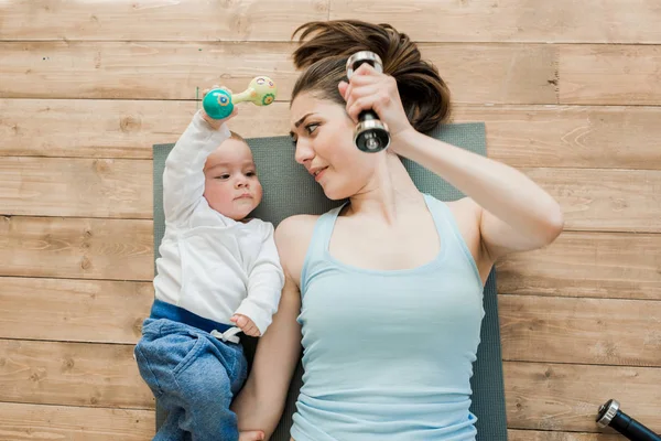 Mother and baby boy playing with dumbbells — Stock Photo, Image