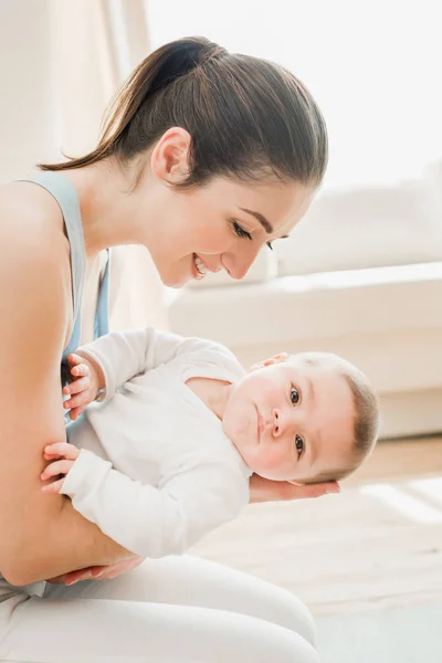 Joven madre abrazando bebé niño — Foto de Stock