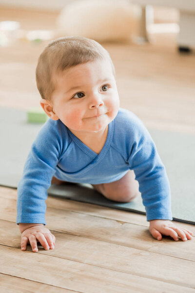 baby boy crawling on yoga mat
