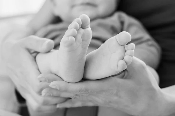Child 's feet in mother' s hands — стоковое фото