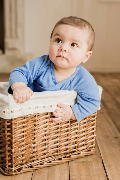 Menino sentado em caixa trançada — Fotografia de Stock