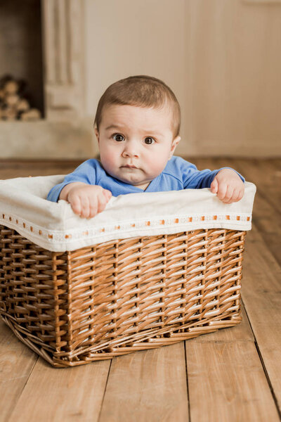 Baby boy sitting in braided box