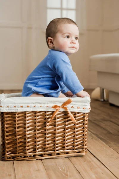 Chlapeček sedí v pletené krabice — Stock fotografie