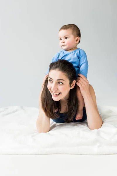 Madre joven con el niño acostado en la cama — Foto de Stock