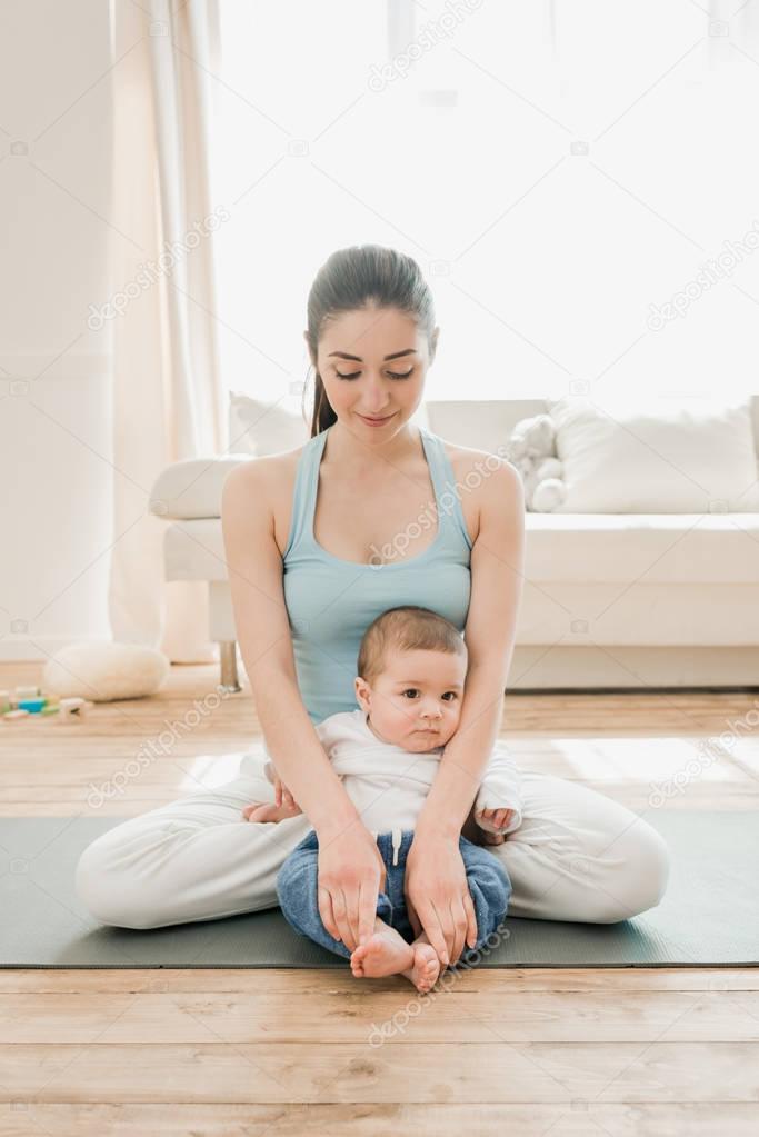 woman with child sitting in lotus position