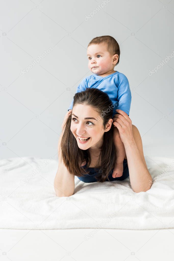 Young mother with child lying on bed