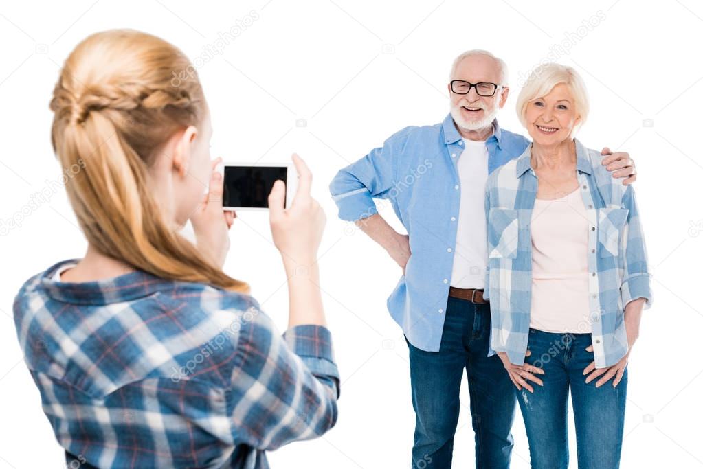granddaughter taking photo of grandparents