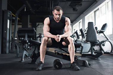 sportsman sitting at gym looking at camera