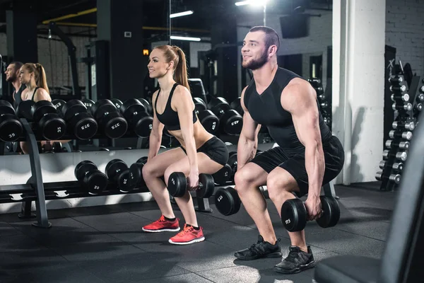 Pareja haciendo ejercicio con pesas — Foto de Stock