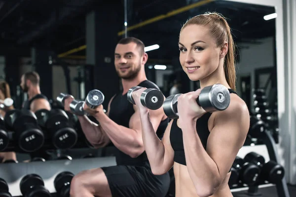 Young couple training with dumbbells together — Stock Photo, Image